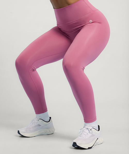 Dusty rose pink leggings worn by a person on a light gray background
